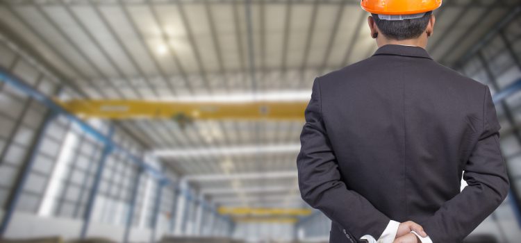 engineer holding orange helmet for workers security on factory background