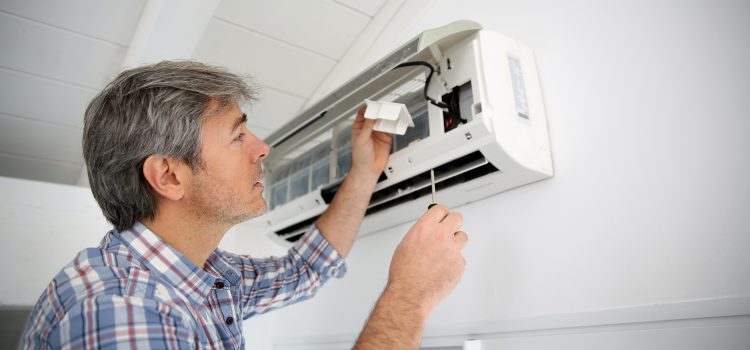 Repairman fixing air conditioner unit